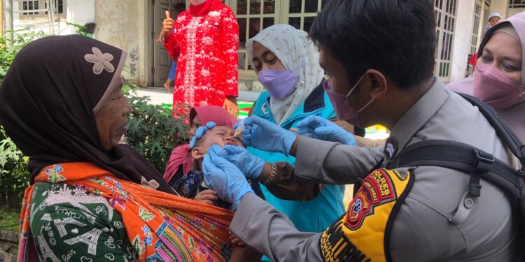 Bhabinkamtibmas Polsek Mande melaksanakan Pendampingan Dalam Pemberian Tetes Polio